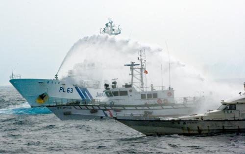 臺(tái)灣“海巡署”的巡邏船（中）在掩護(hù)保釣船“全家福”號(hào)（右）躲避日本海上保安廳巡視船的水炮攻擊。