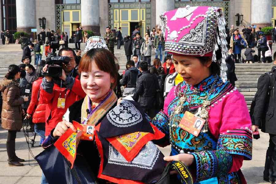 云南代表團的兩位女代表在為記者展示她們帶來的民族特色手工藝品。 人民網記者 馬麗婭 攝