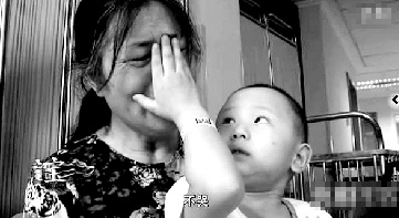 視頻中“小中寶”看到奶奶為他掉眼淚,就伸手為奶奶抹去眼淚。視頻截圖 視頻中“小中寶”看到奶奶為他掉眼淚,就伸手為奶奶抹去眼淚。視頻截圖