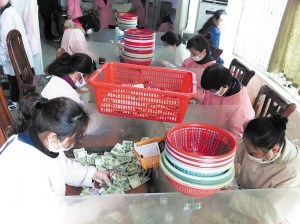 點鈔員們在低頭緊張地工作，她們每人每天都需要點鈔25箱1萬元以上。 陳暄 攝
