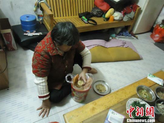17日下午，56歲小兒麻痹癥患者張紅英爬在地板上找東西。 蘇路程 攝