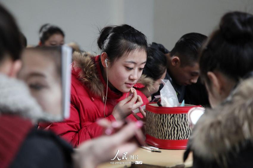 2014年2月17日，山東濱州，藝考候考考生在濱州學(xué)院報(bào)名點(diǎn)化妝。